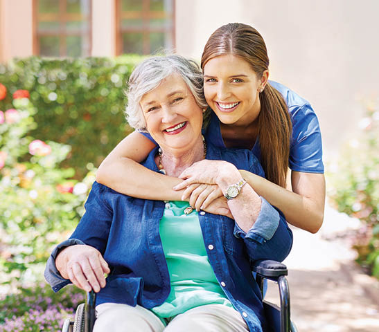 Shot of a resident and a nurse outside in the retirement home garden